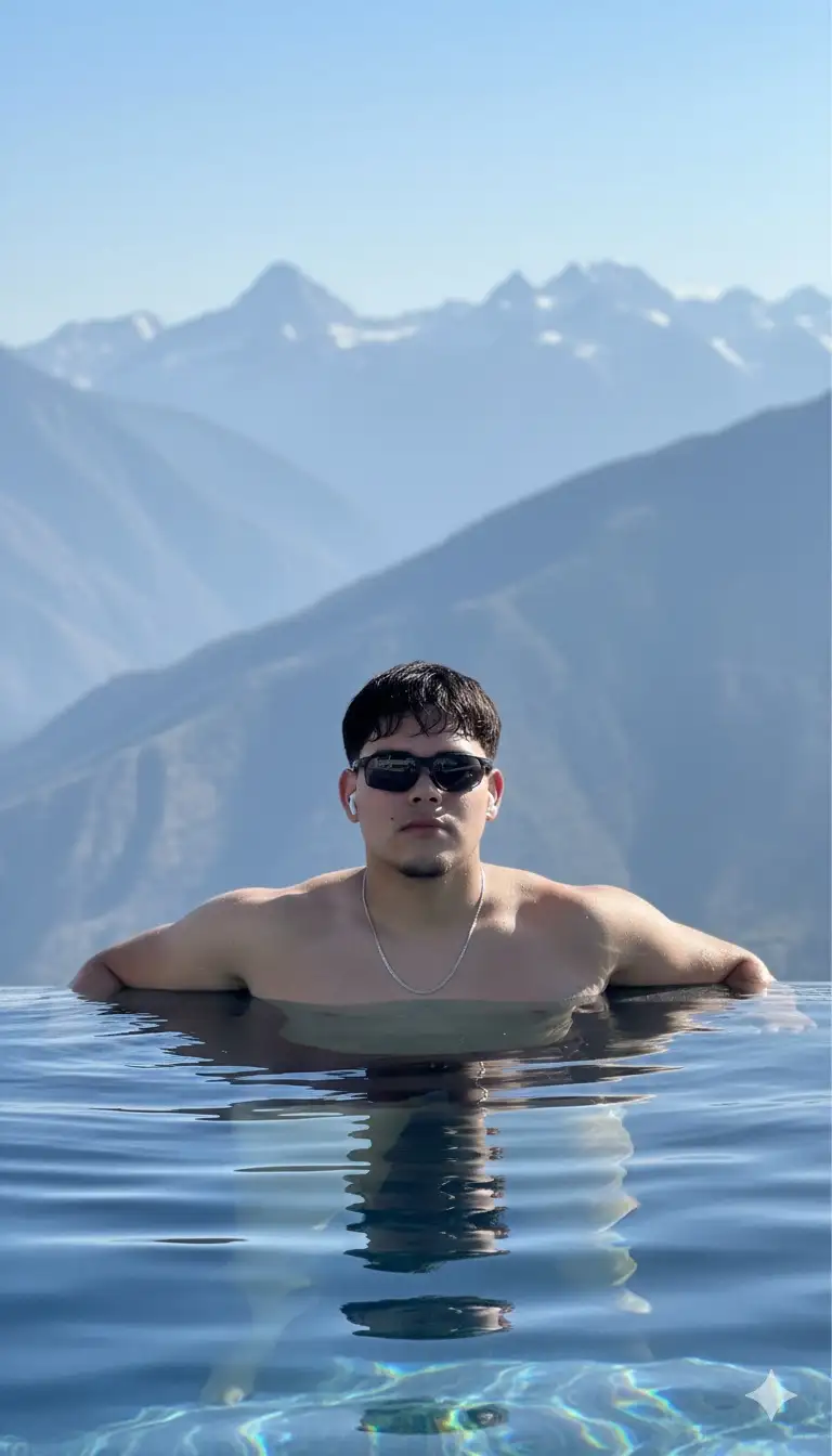 Eres un fotógrafo profesional y realizarás este retrato cinematográfico usando de modelo al sujeto de la foto.
Fotografía de estilo de vida cinematográfico usando de modelo al chico de la foto, una toma de alta costura y aspiracional de un joven guapo y atlético. Lleva gafas deportivas y una fina cadena plateada, relajándose al borde de una lujosa piscina infinita, sumergida hasta el pecho con el pelo algo mojado. El fondo son montañas nevadas moderno vasto, extenso y brumoso. La iluminación es brillante, luz solar directa, proyecta reflejos nítidos en su piel y crea ondas en el agua azul oscura. El estado de ánimo general es de lujo, éxito y tranquilidad de alta gama. Detalles fotorrealistas con nítidos sobre el tema.
Resolución de 8k, hiperrealista, FHD.
--Ar 9: 16 --estilo crudo --v 6,0