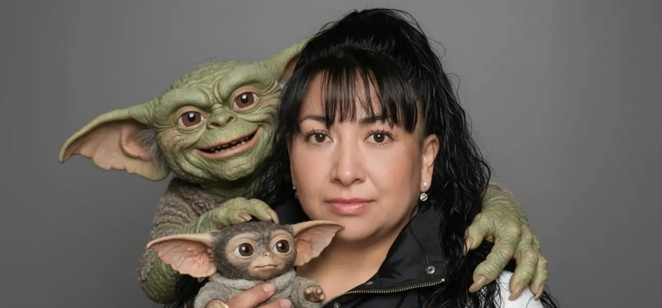 Una mujer sonriente, Detrás de ella, un Gremlin adulto lo abraza por los hombros, y él sostiene un adorable Gizmo en sus manos. Fondo oscuro. Retrato de estudio. Reemplaza la cara de la persona con la foto adjunta Mantén el rostro sin cambiarlo y sin modificarlo